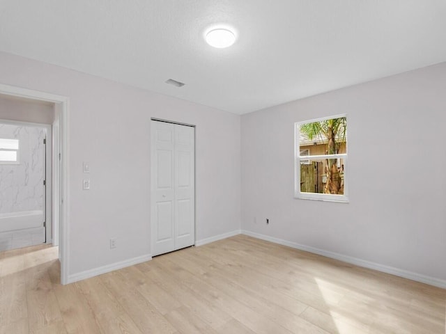 unfurnished bedroom featuring a closet and light hardwood / wood-style flooring