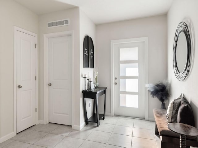 foyer entrance featuring light tile patterned floors, visible vents, and baseboards