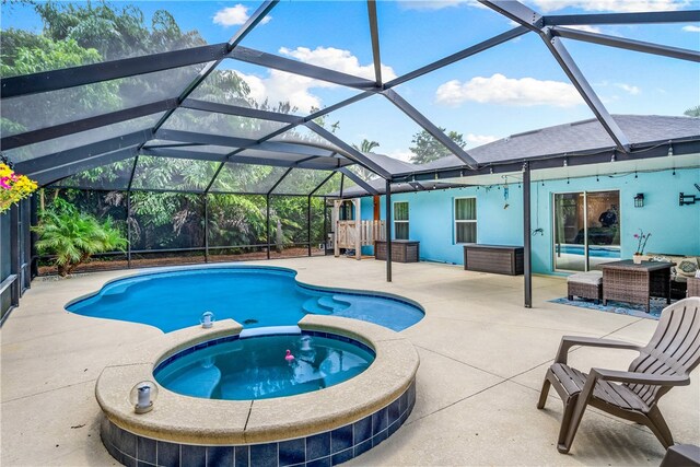 view of pool featuring glass enclosure and a patio