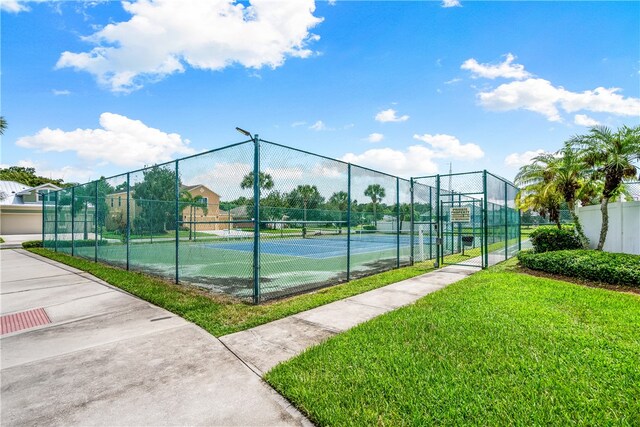 view of sport court with a yard