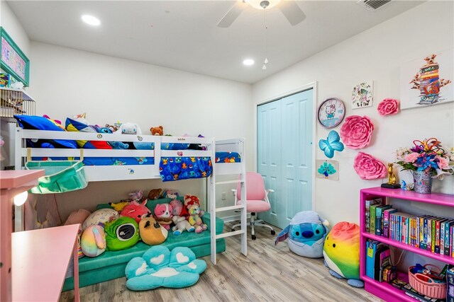 bedroom featuring hardwood / wood-style floors, ceiling fan, and a closet