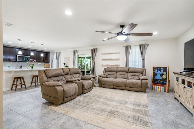 living room featuring light tile patterned floors and ceiling fan