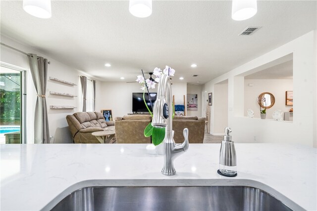 kitchen with light stone countertops and sink