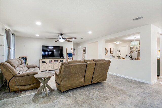 living room featuring ceiling fan with notable chandelier