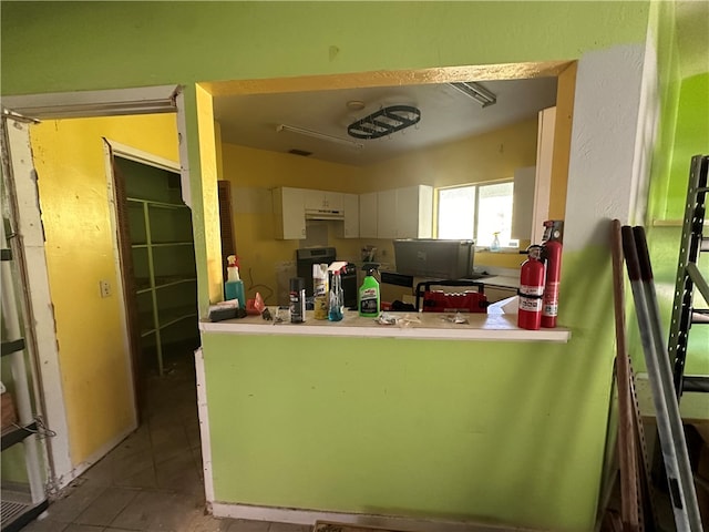 kitchen with white cabinetry, tile patterned flooring, and stove