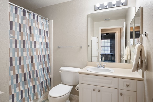 bathroom with a shower with shower curtain, vanity, and toilet