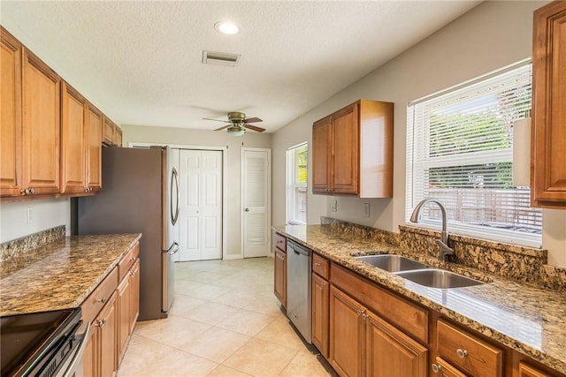 226 21st Ave, Vero Beach, FL 32962 - kitchen featuring a sink, stainless steel appliances, a textured ceiling, a ceiling fan, and brown cabinetry