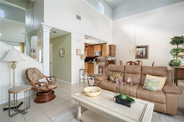 living room with decorative columns, high vaulted ceiling, and light tile patterned floors