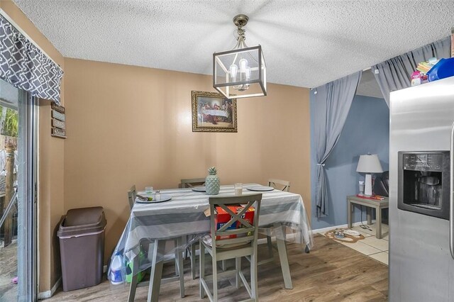 dining room featuring a chandelier, hardwood / wood-style floors, and a textured ceiling