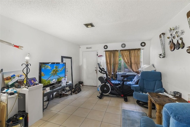 workout room featuring light tile patterned flooring and a textured ceiling