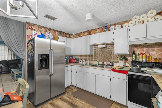 kitchen featuring sink, white cabinetry, range with electric stovetop, a textured ceiling, and stainless steel fridge with ice dispenser