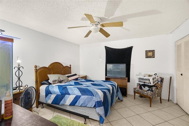 tiled bedroom with a textured ceiling, a closet, and ceiling fan