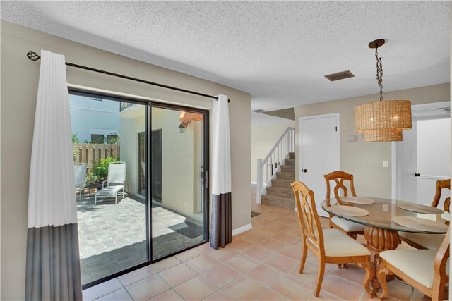 1011 Royal Palm Blvd Unit B3, Vero Beach, FL 32960 - dining area featuring a textured ceiling, stairway, light tile patterned floors, and a chandelier