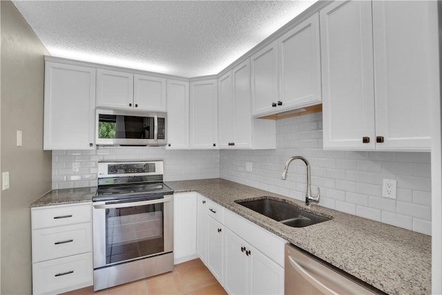 1011 Royal Palm Blvd Unit B3, Vero Beach, FL 32960 - kitchen featuring appliances with stainless steel finishes, light stone counters, decorative backsplash, and a textured ceiling