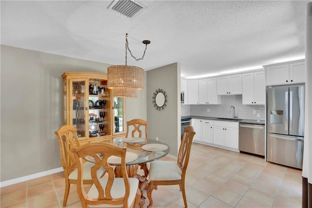 1011 Royal Palm Blvd Unit B3, Vero Beach, FL 32960 - dining area featuring a textured ceiling, light tile patterned floors, and a chandelier