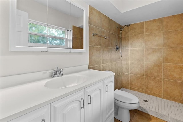 bathroom featuring vanity, tiled shower, and toilet