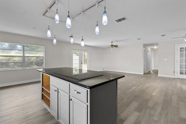 kitchen with french doors, white cabinetry, a center island, pendant lighting, and ceiling fan