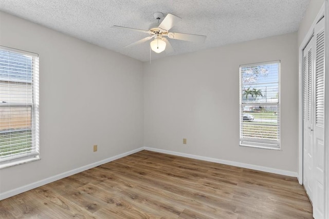 spare room featuring a textured ceiling, light hardwood / wood-style flooring, and ceiling fan