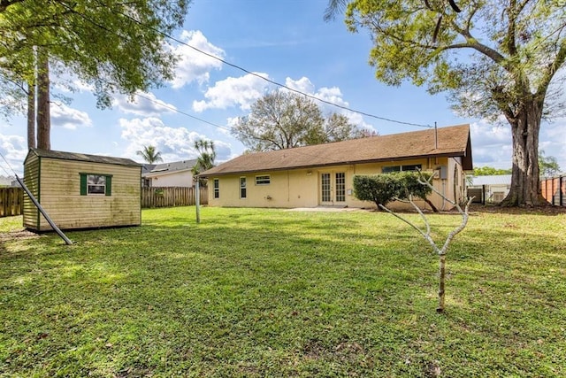 rear view of house with french doors, a storage shed, and a yard