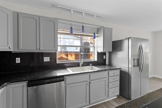 kitchen featuring sink, gray cabinetry, backsplash, stainless steel appliances, and wood-type flooring