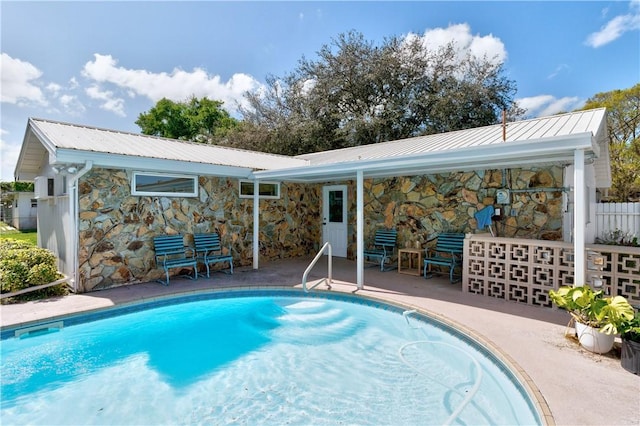 rear view of house with a fenced in pool