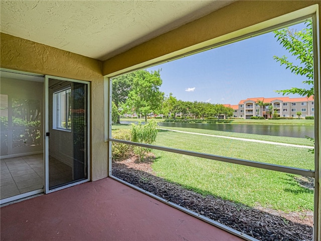 unfurnished sunroom featuring a water view