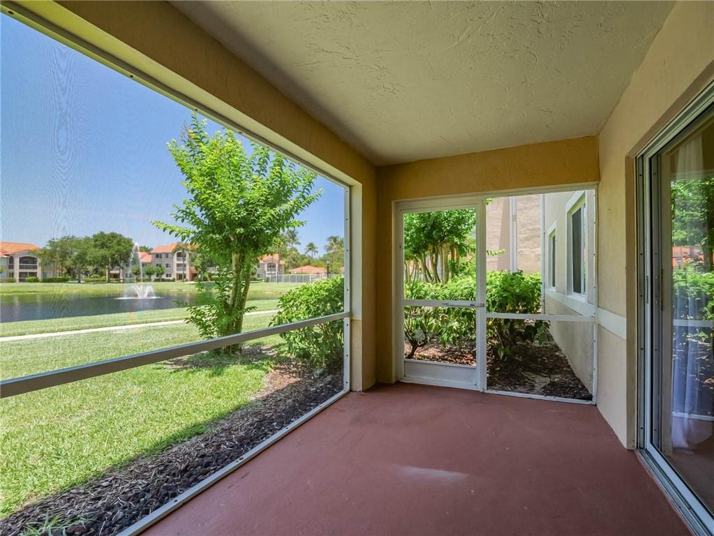 unfurnished sunroom featuring a water view