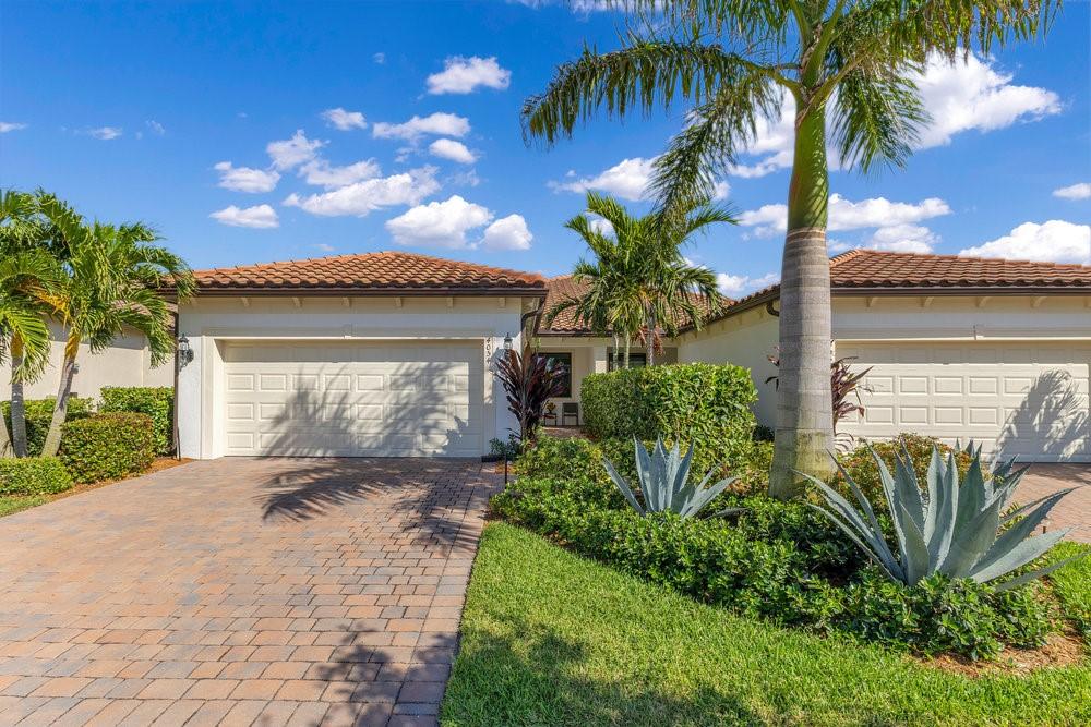 4054 Basket Oak Cir, Vero Beach, FL 32967 - mediterranean / spanish home featuring decorative driveway, a tiled roof, an attached garage, and stucco siding