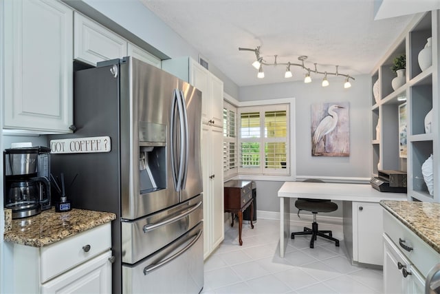 kitchen with white cabinetry, stainless steel refrigerator with ice dispenser, light tile patterned floors, and light stone countertops