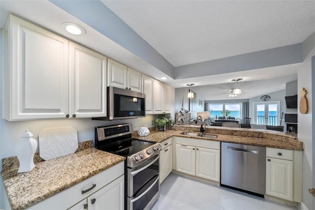 kitchen with white cabinets, stainless steel appliances, lofted ceiling, and sink