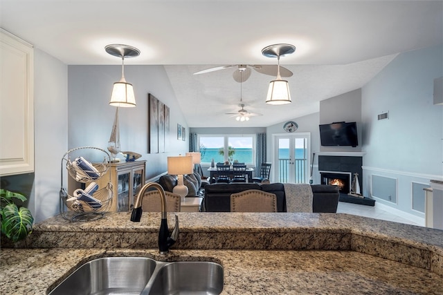 kitchen featuring lofted ceiling, sink, ceiling fan, and hanging light fixtures