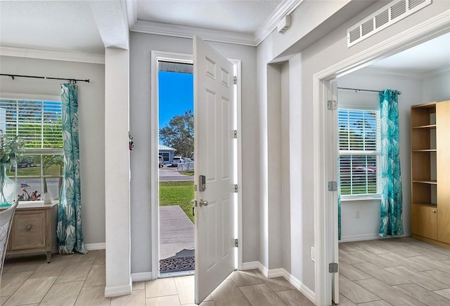 foyer entrance featuring ornamental molding, visible vents, and baseboards