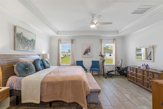 bedroom featuring visible vents, a ceiling fan, a tray ceiling, a textured ceiling, and crown molding