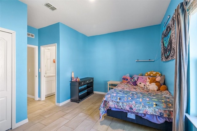 bedroom featuring wood finish floors, visible vents, and baseboards