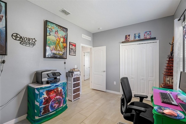 office area featuring light wood finished floors, visible vents, and baseboards