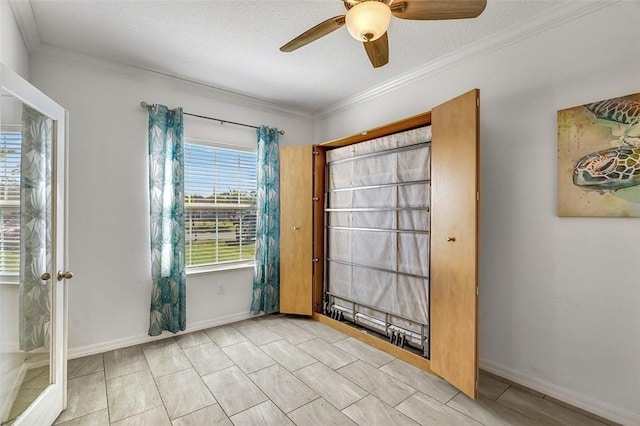 empty room with crown molding, a textured ceiling, and baseboards