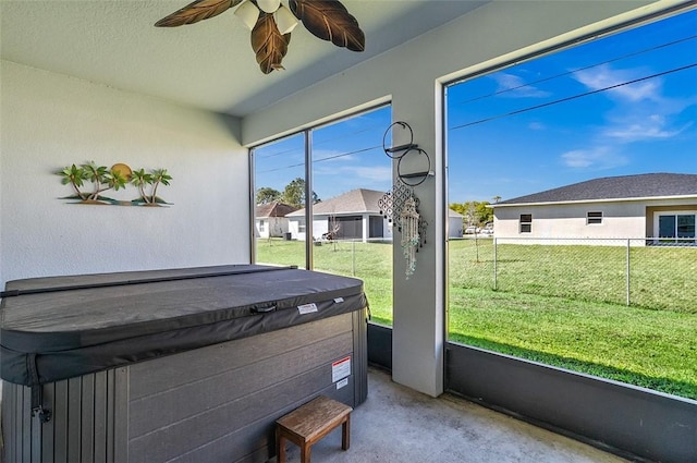 sunroom with a residential view and a ceiling fan