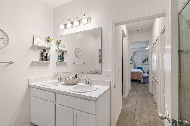 ensuite bathroom with double vanity, connected bathroom, a sink, and tile patterned floors