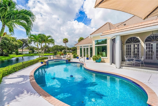 view of pool with a patio area, an in ground hot tub, and a water view