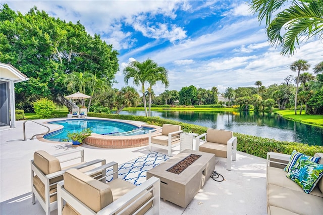 view of swimming pool with a patio, a water view, and an outdoor living space with a fire pit