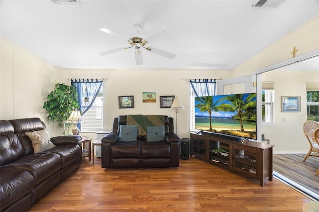 living area featuring ceiling fan, visible vents, and wood finished floors