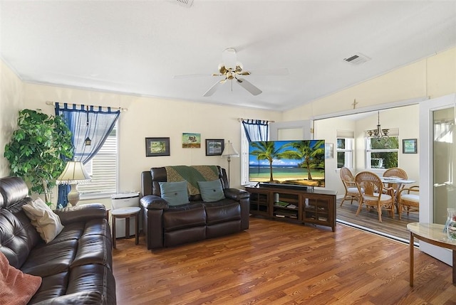 living room featuring ceiling fan, visible vents, vaulted ceiling, and wood finished floors