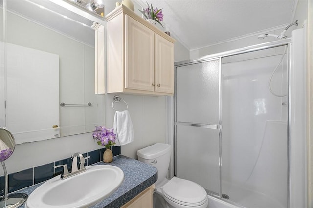 bathroom with vanity, a shower stall, and toilet