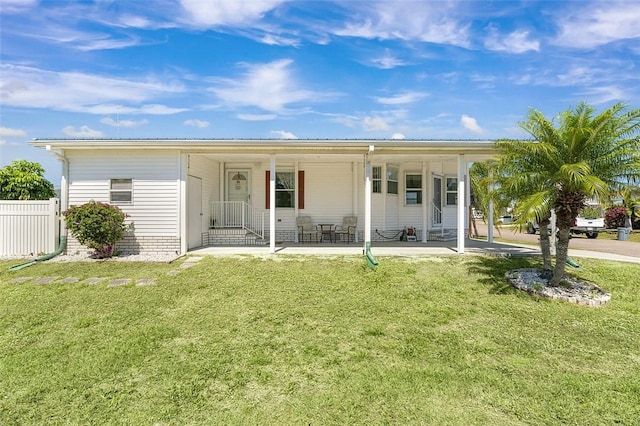 back of property with entry steps, a yard, and fence