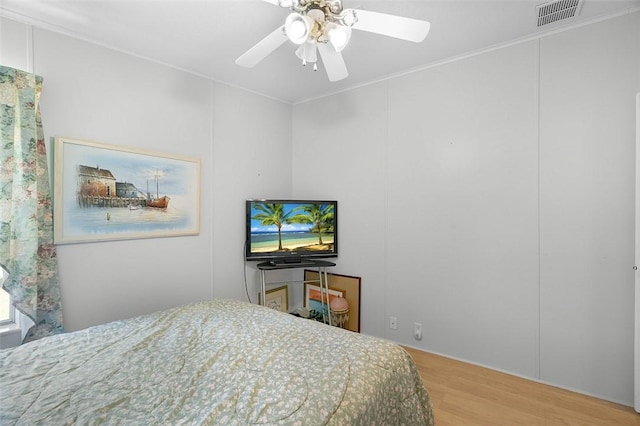 bedroom with wood finished floors, visible vents, and a ceiling fan