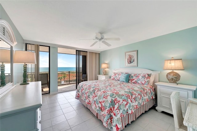 bedroom with a water view, access to exterior, a wall of windows, and a ceiling fan