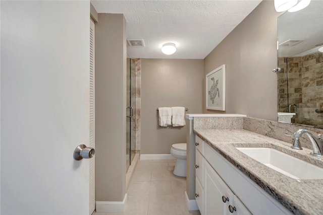 full bathroom with a stall shower, vanity, a textured ceiling, and tile patterned floors