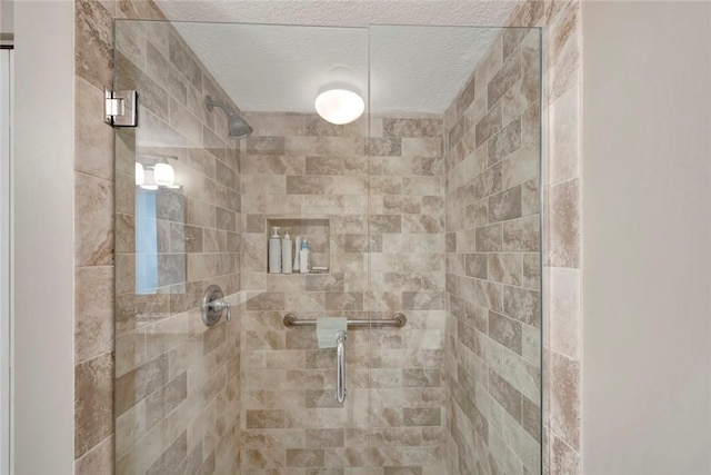 bathroom featuring a shower stall and a textured ceiling