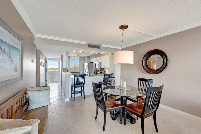 dining room with a textured ceiling, light tile patterned flooring, visible vents, and crown molding