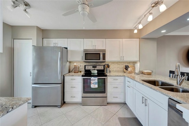 kitchen with stainless steel appliances, backsplash, a sink, and white cabinetry